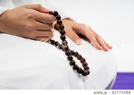 Close up of woman hands praying with prayer beads Close up of woman hands praying with prayer beads 92773498