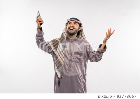 asian youth in a turban using a mobile phone excitedly over white asian youth in a turban using a mobile phone excitedly over white 92773667