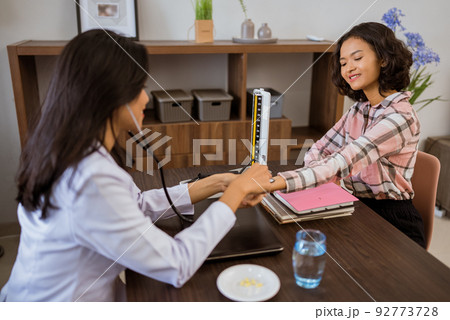 female patient checked heart rate by doctor with stethoscope female patient checked heart rate by doctor with stethoscope 92773728