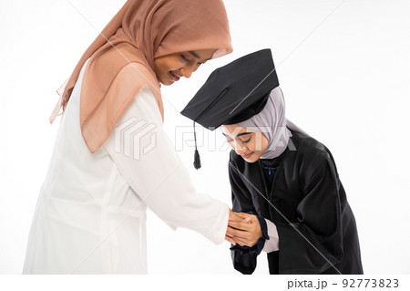 Close up of female graduate student shaking hands with mother Close up of female graduate student shaking hands with mother 92773823