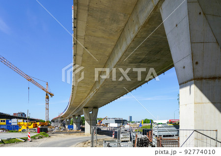 New modern road overpass concrete bridge construction site with yellow tower crane 92774010
