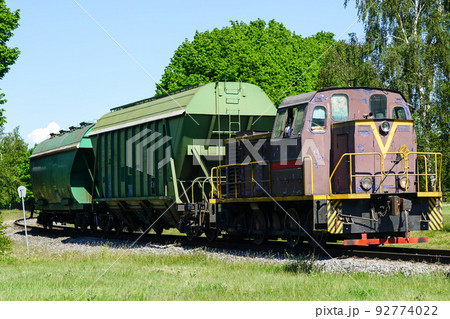 a small shunting diesel locomotive pulls two bulk wagons 92774022