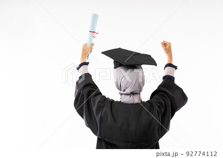 Rear behind view photo of female college graduate wearing toga Rear behind view photo of female college graduate wearing toga 92774112