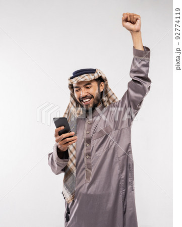 asian youth in a turban using a mobile phone excitedly over white 92774119