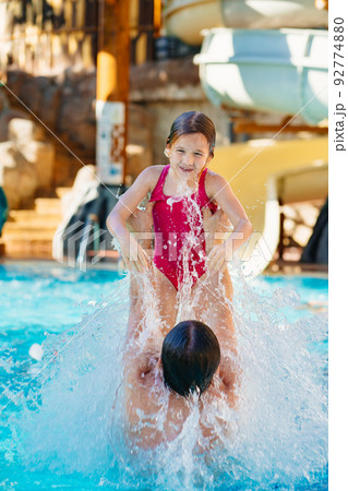 dad throws up his daughter, they have fun and play together in the pool. dad throws up his daughter, they have fun and play together in the pool. 92774880