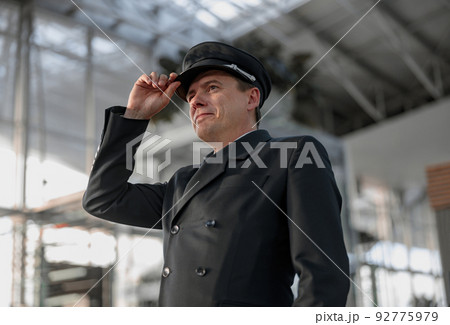 Pilot adjusting his cap and looking ahead of himself Pilot adjusting his cap and looking ahead of himself 92775979