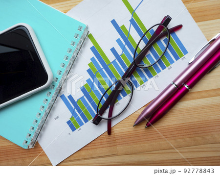 グラフ、手帳、メガネ、スマホのビジネスイメージ (女性) 92778843