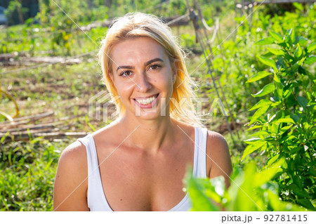 Attractive young blonde woman posing in home garden 92781415