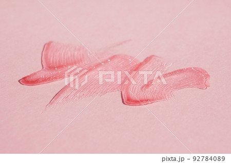 Smears of transparent shining lip gloss on a pink background Smears of transparent shining lip gloss on a pink background 92784089