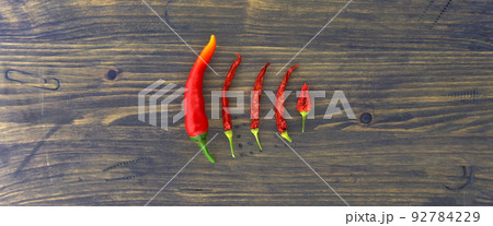 Hot chili pepper panorama still life over a wood background Hot chili pepper panorama still life over a wood background 92784229
