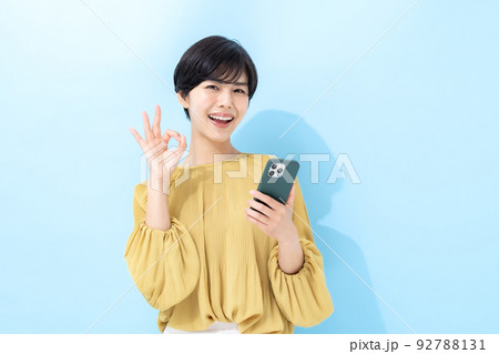 女性　スマートフォン　ブルーバック 92788131