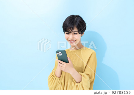 女性　スマートフォン　ブルーバック 92788159