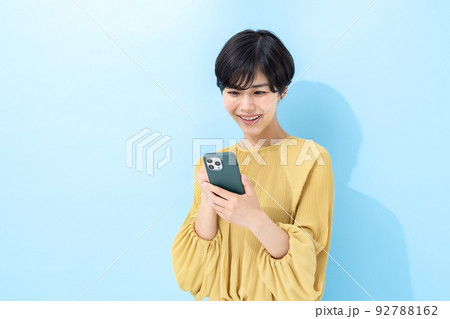 女性　スマートフォン　ブルーバック 92788162