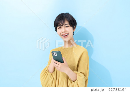 女性　スマートフォン　ブルーバック 92788164