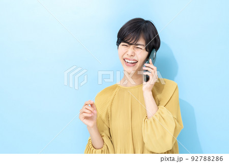 女性　スマートフォン　ブルーバック 92788286
