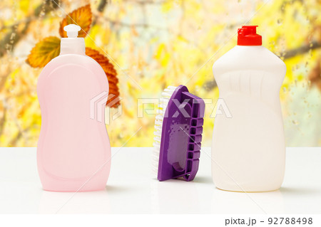 Bottles of washing liquid and brush on white background. Bottles of washing liquid and brush on white background. 92788498
