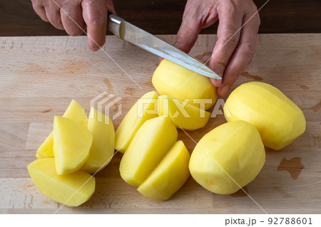 Hands with knife cutting potatoes, preparing potatoes for cooking. Hands with knife cutting potatoes, preparing potatoes for cooking. 92788601