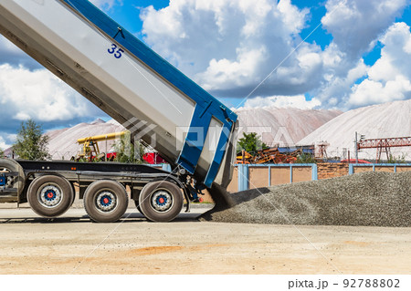 A large dump truck unloads rubble or gravel at a construction site. Car tonar for transportation of heavy bulk cargo. Providing the construction site with materials. A large dump truck unloads rubble or gravel at a construction site. Car tonar for transportation of heavy bulk cargo. Providing the construction site with materials. 92788802