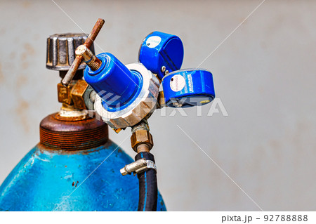 Blue Oxygen cylinder with faucet valve and manometers appliances closeup, metal gas cutting equipment. 92788888
