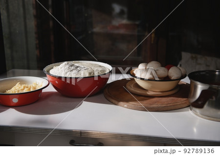 Assortment of cooking ingredients for baking pizza in enamel bowls on table in rustic kitchen. Food still life. Close-up 92789136