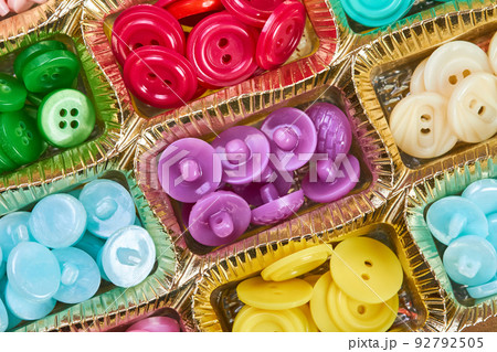 Close-up of a box with a set of multi-colored buttons in plastic cells Close-up of a box with a set of multi-colored buttons in plastic cells 92792505