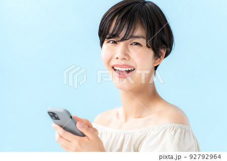 女性　スマートフォン　ブルーバック 92792964