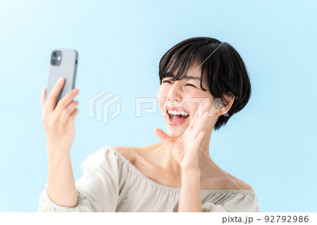 女性　スマートフォン　ブルーバック 92792986