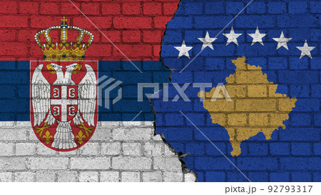 Serbia vs Republic of Kosovo, flags on a wall with break in the background. Concept of military conflict 92793317