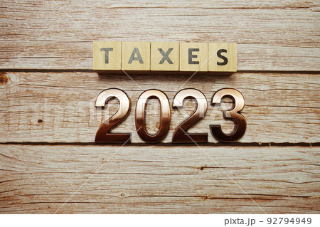 Taxes 2023 alphabet letter on wooden background Taxes 2023 alphabet letter on wooden background 92794949