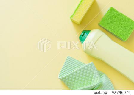 Cleaning concept - cleaning supplies on pastel yellow background Cleaning concept - cleaning supplies on pastel yellow background 92796976