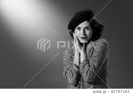 Portrait of beautiful woman in image of famous fashion designer posing in stylish classical clothes, jacket and hat. Black and white photography Portrait of beautiful woman in image of famous fashion designer posing in stylish classical clothes, jacket and hat. Black and white photography 92797162