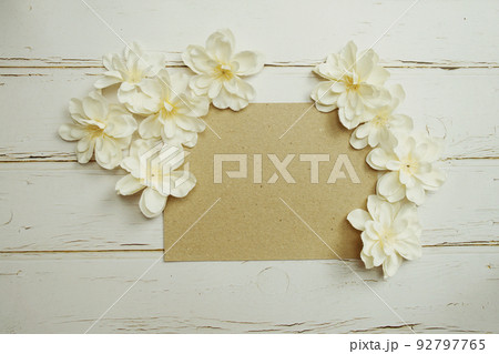 Empty paper craft with flower bouquet Top view on wooden background Empty paper craft with flower bouquet Top view on wooden background 92797765