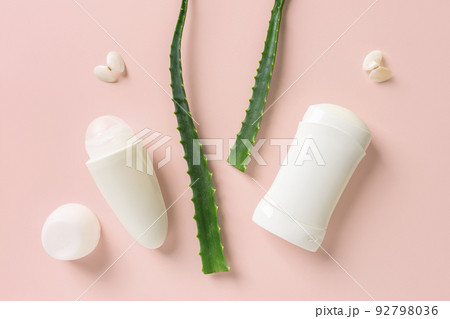 Two fresh green aloe leaves between roll on deodorant and solid antiperspirant. Two fresh green aloe leaves between roll on deodorant and solid antiperspirant. 92798036