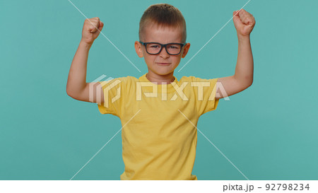Sporty toddler children boy showing biceps and looking confident, feeling power strength success win Sporty toddler children boy showing biceps and looking confident, feeling power strength success win 92798234