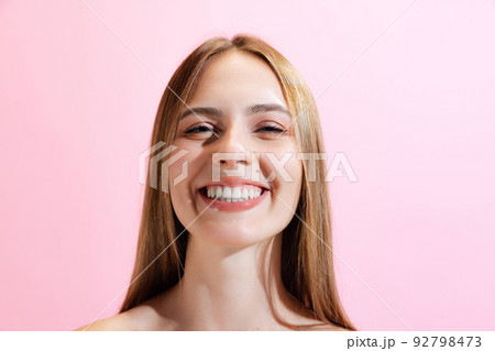 Closeup face of young beautiful girl, student looking at camera isolated on pink background. Concept of beauty, art, fashion, human emotions 92798473