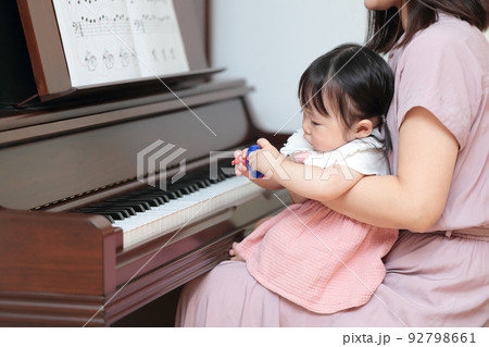 アップライトピアノを弾く1歳の女の子とママ 92798661
