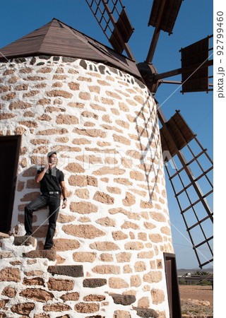 man leaning on the wall of a windmill man leaning on the wall of a windmill 92799460