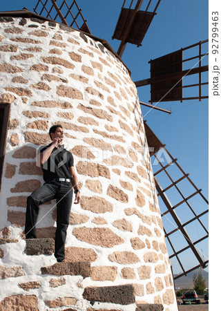 man leaning on the wall of a windmill man leaning on the wall of a windmill 92799463