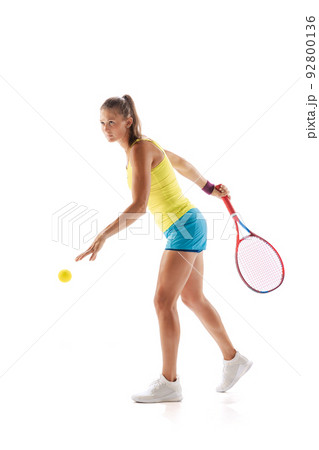 Portrait of young woman, professional tennis player training, serving ball isolated over white studio background Portrait of young woman, professional tennis player training, serving ball isolated over white studio background 92800136