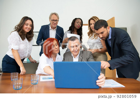 Business team of men and women in an office analyzing the evolution of the company 92801059