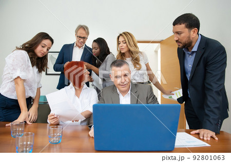 Business team of men and women in an office analyzing the evolution of the company 92801063