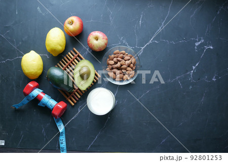 mixed nut in a bowl, milk and dumbbell on table  92801253