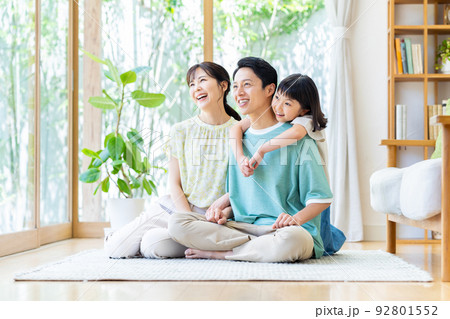 リビングでくつろぐ若い家族 92801552