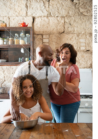 African American family having fun in their home kitchen while cooking a cake together 92802525