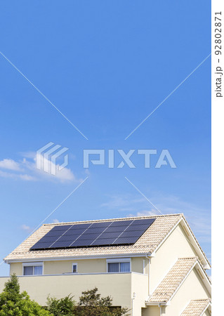 【環境イメージ】太陽光パネルが設置された住宅の屋根と快晴の青空。 92802871