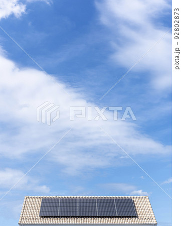 【環境イメージ】太陽光パネルが設置された住宅の屋根と快晴の青空。 92802873