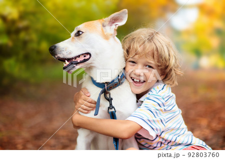 Child playing with his dog. Kids and dogs. 92803760