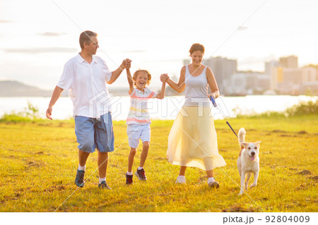 Family with kids running outdoor at sunset. Family with kids running outdoor at sunset. 92804009