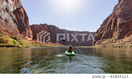 Adventurous Woman on a Kayak paddling in Colorado River. Glen Canyon, Arizona Adventurous Woman on a Kayak paddling in Colorado River. Glen Canyon, Arizona 92804121