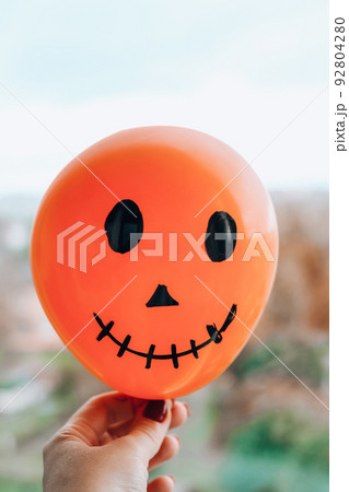 Painted Jacks face on balloons. Orange and white balls preparation diy for halloween party. Halloween home activities. Handmade toys Painted Jacks face on balloons. Orange and white balls preparation diy for halloween party. Halloween home activities. Handmade toys 92804280